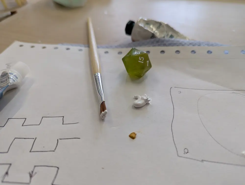 picture of half-painted dice and paint brush