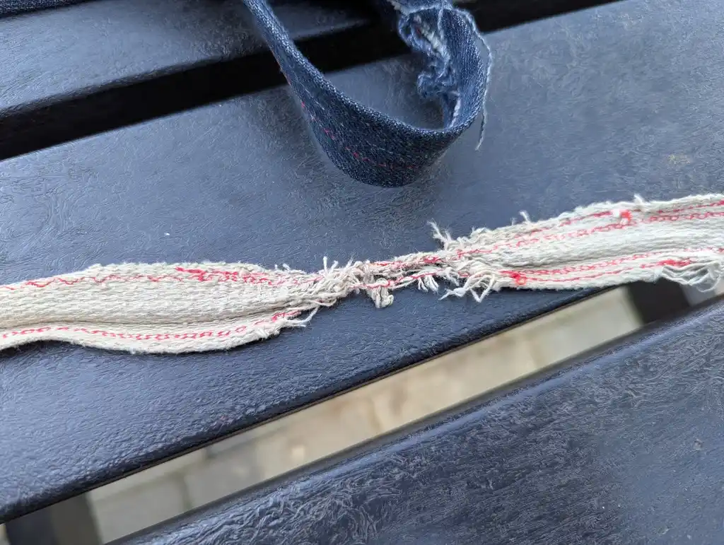 picture of broken bag strap showing threads