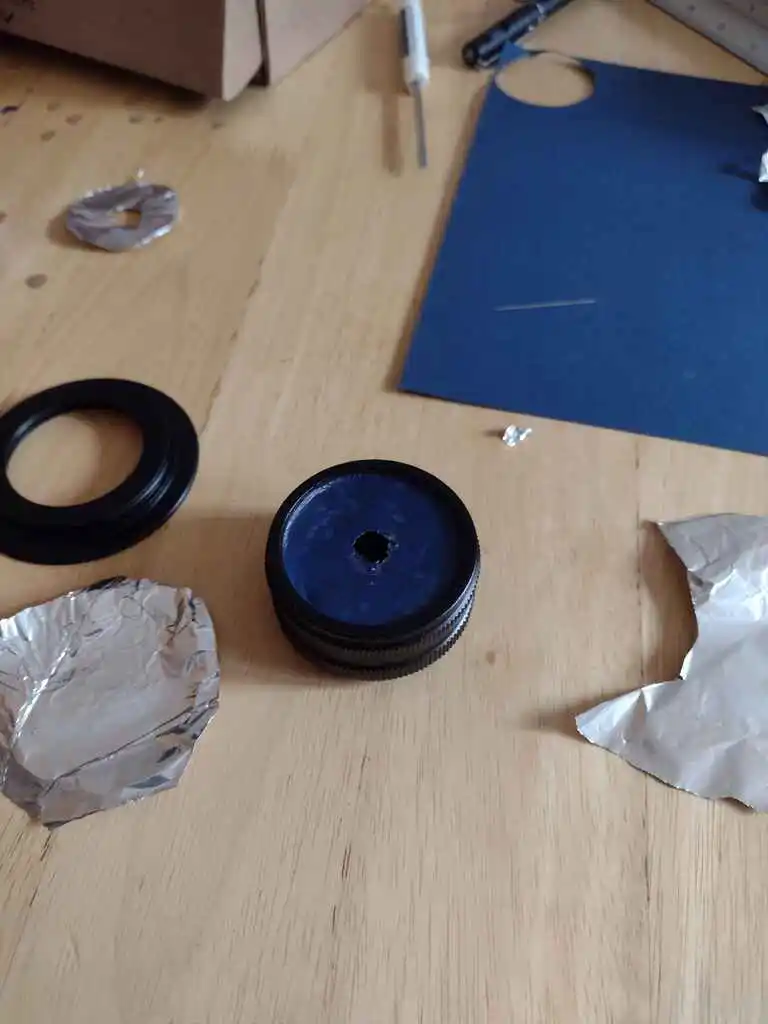 picture of camera lens with small hole bored in the middle