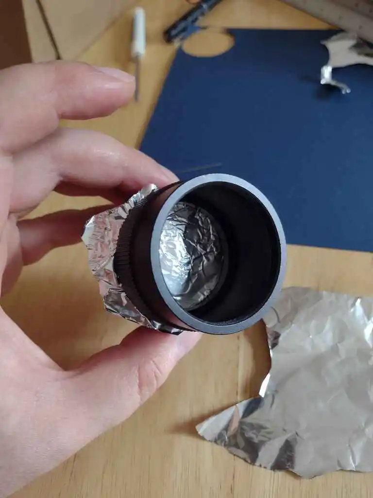 picture of camera lens with tinfoil covering aperture