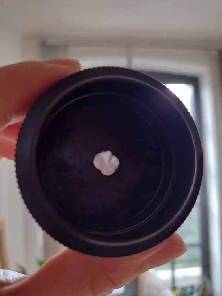 picture of a very small pin-hole in some tinfoil, inside a camera lens