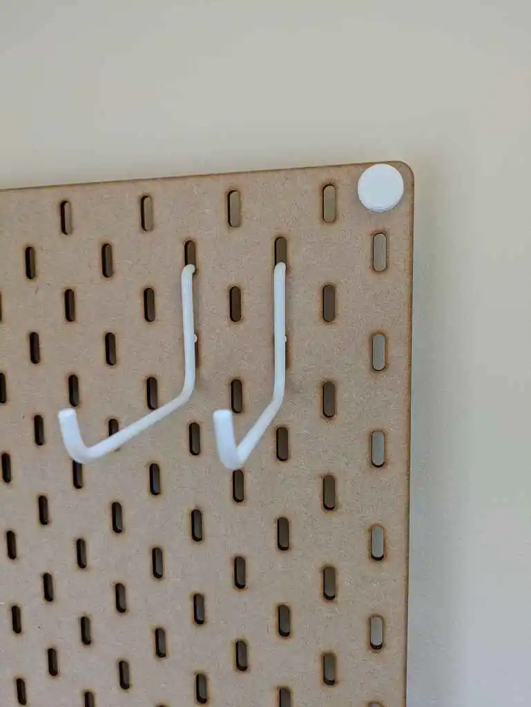 picture of two hooks in two holes in a board