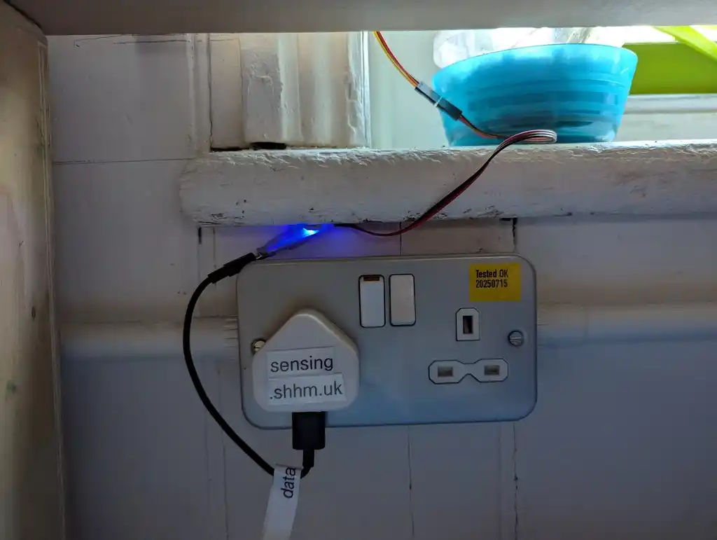 picture of power plug labelled sensing.shhm.uk connected to cable and microcontroller