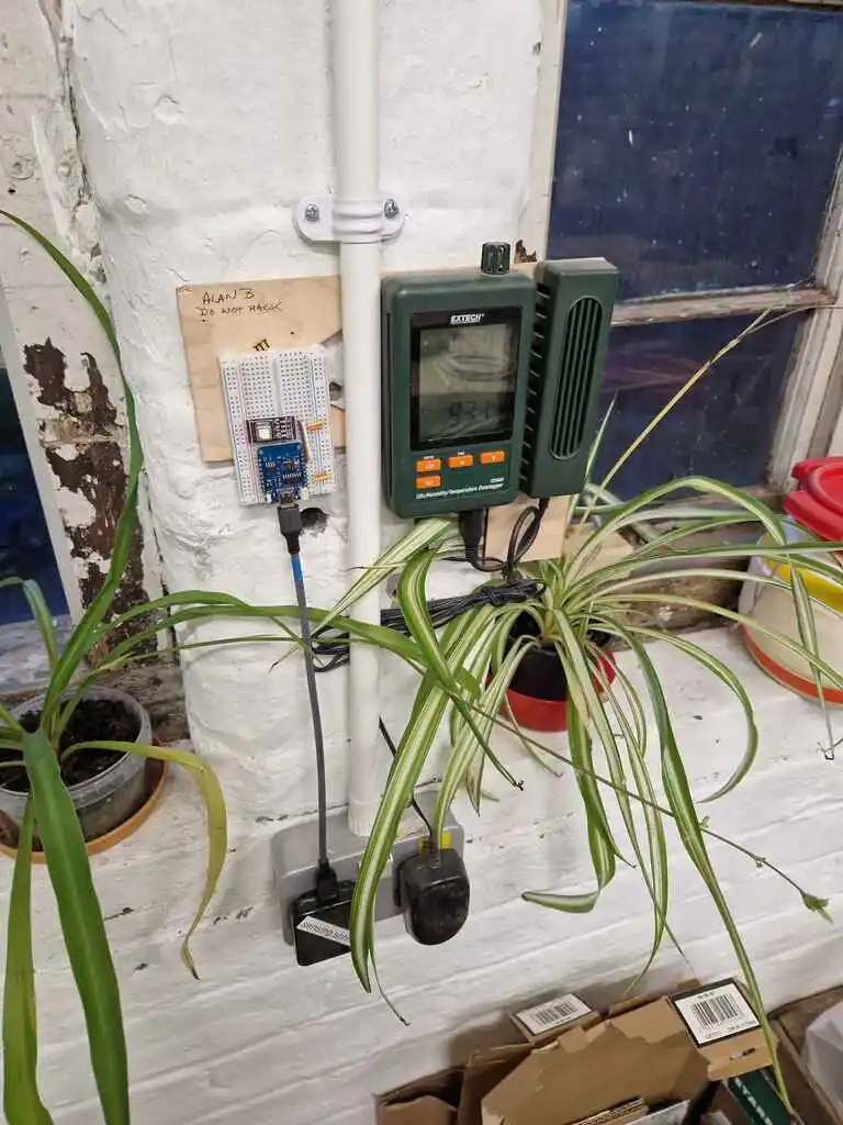 picture of environment monitor stuck to wall above plug socket