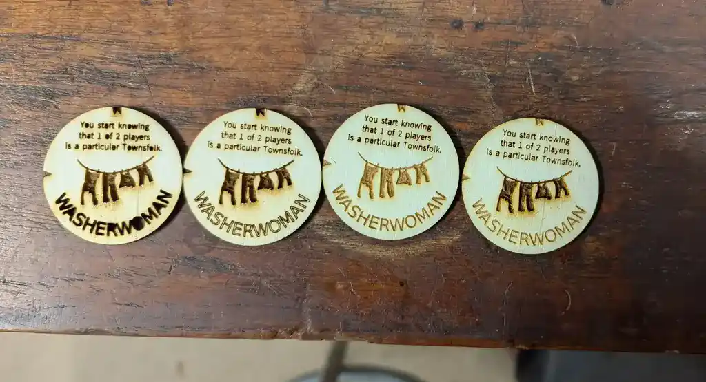 picture of four board game tokens which have been laser cut, getting more readable progressing rightwards
