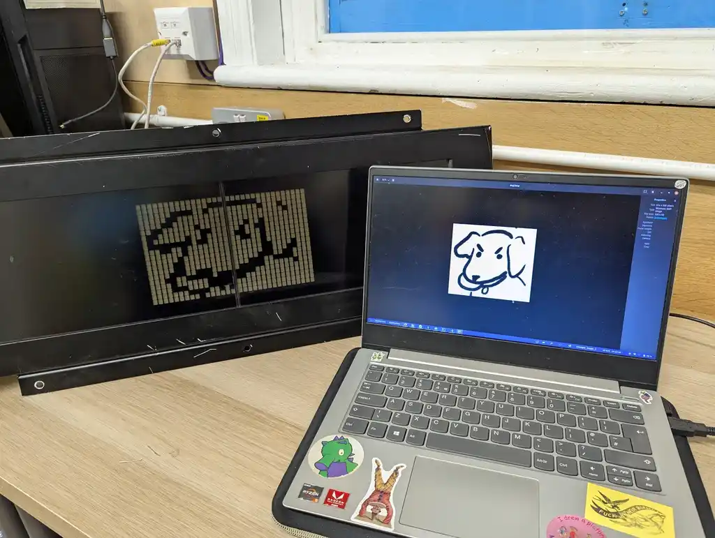 picture of picture on a laptop, and the same picture on a transport sign. picture is of a dog