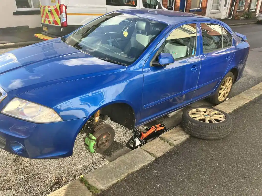 picture of a car, jacked, and with front wheel removed