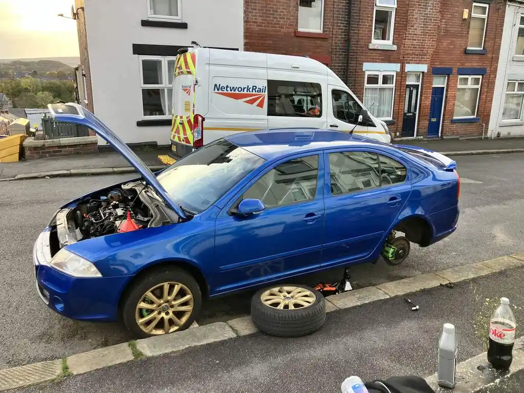 picture of a car, jacked, with rear wheel removed