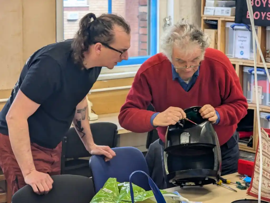 picture of two people and a half-taken-apart air fryer