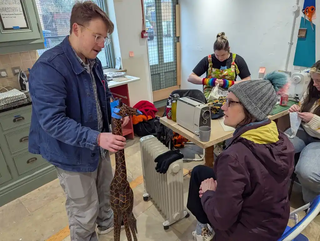 picture of people talking about a standing giraffe