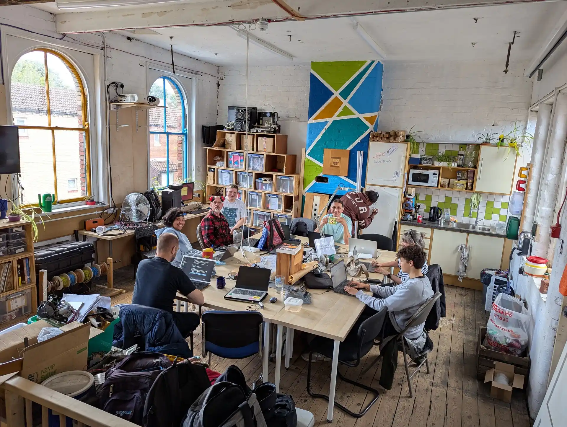 picture of several people sat around a table on their laptops