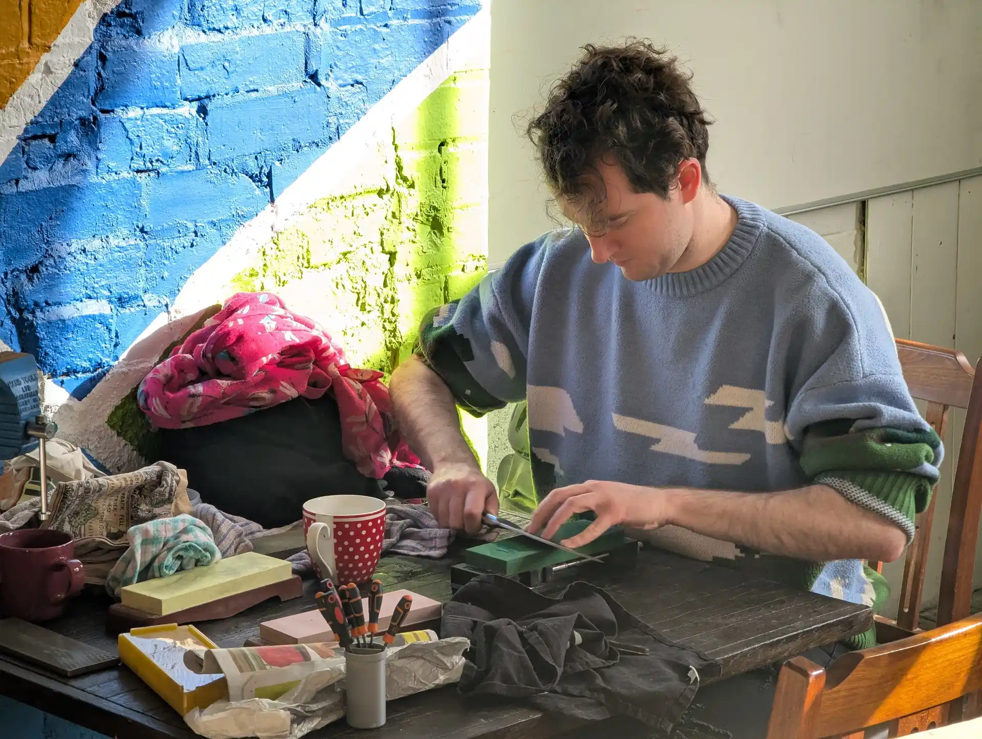 picture of a person sharpening a knife with a sharpening stone